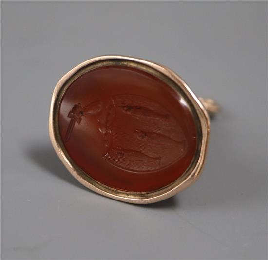 A 19th century yellow metal and carnelian set fob seal, the matrix carved with family crest (a.f.), 43mm.